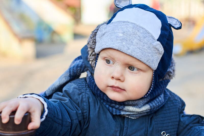 Portrait of a cute little blue-eyed boy with an interested look in a hat, scarf and jacket in early spring stock photography Portrait of a cute little blue-eyed boy with an interested look in a hat, scarf and jacket in early spring stock photography