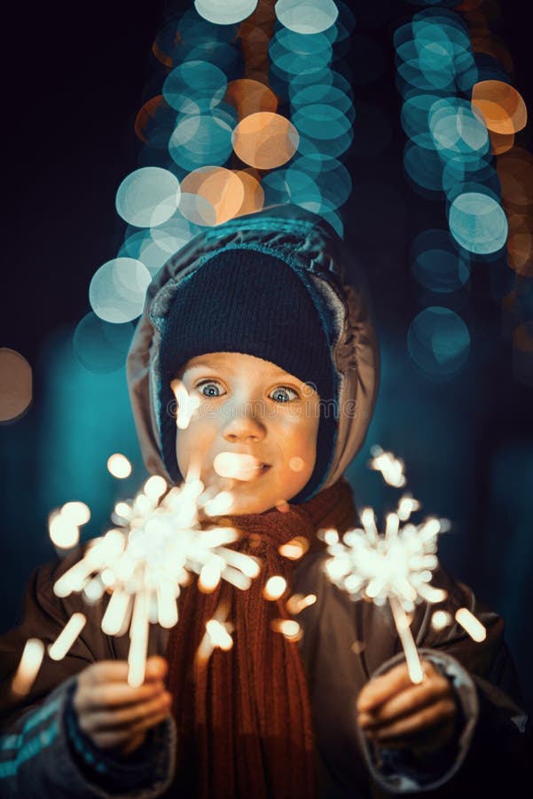 Portrait of a cute little boy holding sparklers