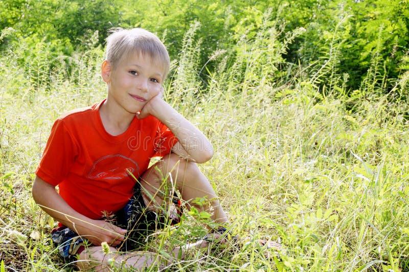 Boy Sitting at Edge of Stream Smiling Stock Photo - Image of preteen ...