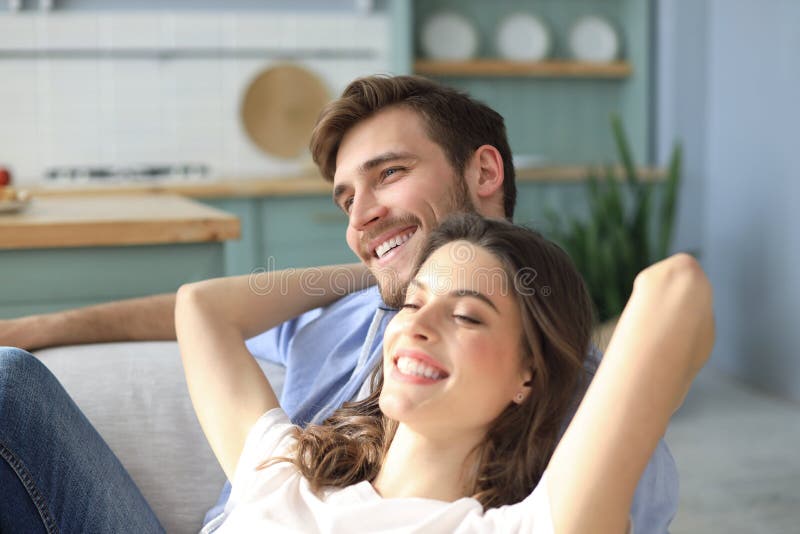 Portrait of cute young couple sitting in sofa