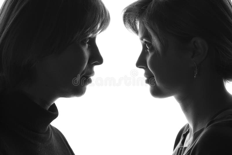 Portrait d'adolescence de mère et de fille sur le fond d'isolement regardant l'un l'autre