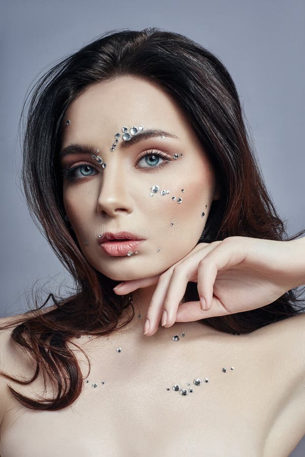 Portrait d'art d'une femme avec de grands cristaux des fausses pierres sur son visage, coffre et corps Maquillage parfait, soins image libre de droits Portrait d'art d'une femme avec de grands cristaux des fausses pierres sur son visage, coffre et corps Maquillage parfait, soins image libre de droits