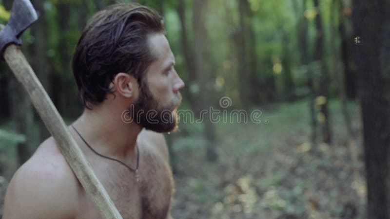 Portrait d'homme barbu bel avec la hache dans la forêt 4K