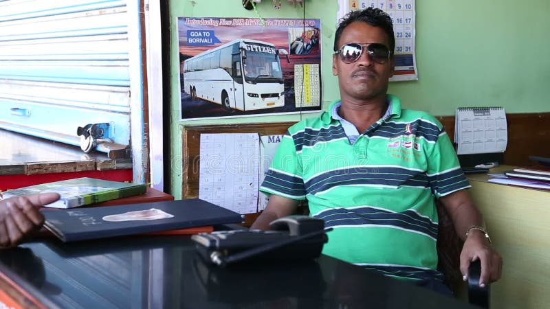 Portrait d'homme indien avec des lunettes de soleil se reposant par un compteur