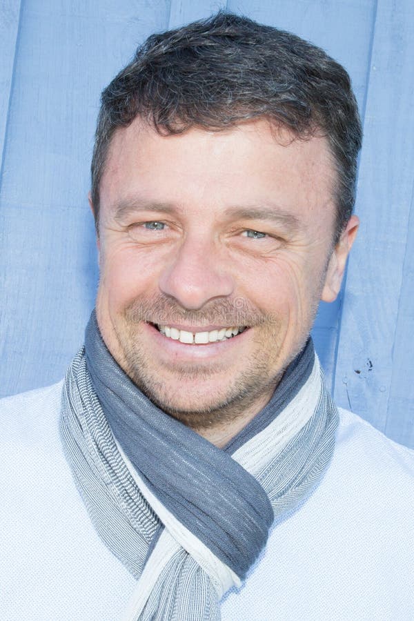 Portrait d'homme plus âgé bel dans la chemise bleue et de scraf avec le grand sourire sur son visage photos libres de droits Portrait d'homme plus âgé bel dans la chemise bleue et de scraf avec le grand sourire sur son visage photos libres de droits