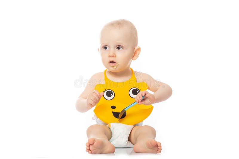 Portrait d'un bébé avec un visage sale d'isolement sur le bébé garçon caucasien heureux blanc et mignon dans le bavoir jaune, se photographie stock libre de droits Portrait d'un bébé avec un visage sale d'isolement sur le bébé garçon caucasien heureux blanc et mignon dans le bavoir jaune, se photographie stock libre de droits