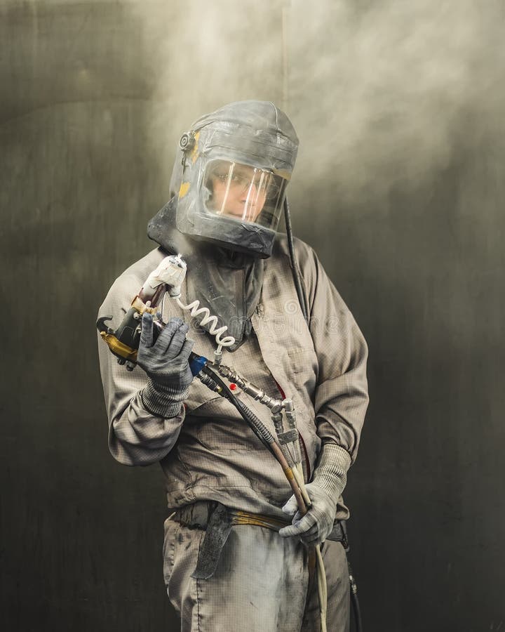 Portrait of an employee of the car body painting shop in protective clothing in the workplace. Portrait of an employee of the car body painting shop in protective clothing in the workplace