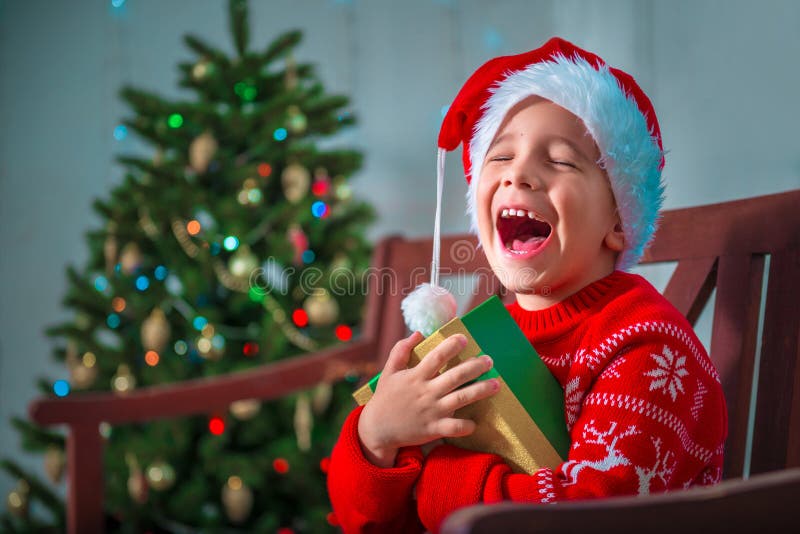   1 Décembre.Bientôt noël . Portrait-d-un-enfant-heureux-avec-cadeau-sur-le-fond-arbre-de-no%C3%ABl-103922006