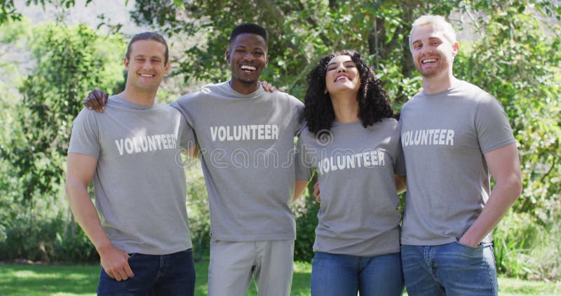 Portrait d'un groupe diversifié et souriant d'amis heureux en t-shirts volontaires embrassant à l'extérieur clips vidéos