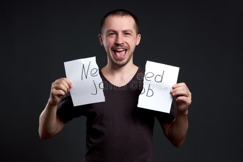 Portrait d'un homme déchirant une inscription sur le papier d'avoir besoin d'un boulot photographie stock libre de droits