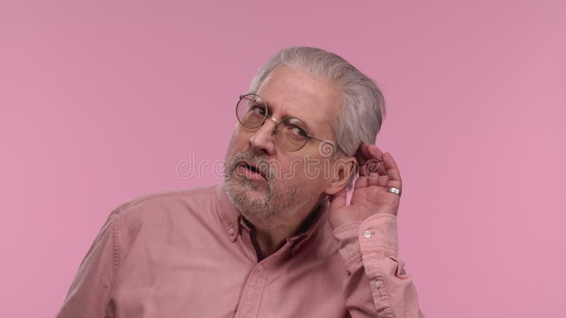 Portrait d'un homme âgé avec des lunettes tenant la main près de l'oreille en essayant d'écouter les nouvelles intéressantes expri