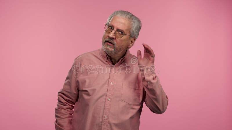 Portrait d'un homme âgé avec des lunettes tenant la main près de l'oreille en essayant d'écouter les nouvelles intéressantes expri