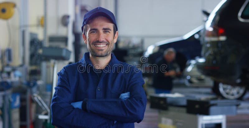 Portrait d'un jeune beau mécanicien de voiture dans un atelier de voiture, à l'arrière-plan du service Concept : réparation des m photo libre de droits Portrait d'un jeune beau mécanicien de voiture dans un atelier de voiture, à l'arrière-plan du service Concept : réparation des m photo libre de droits