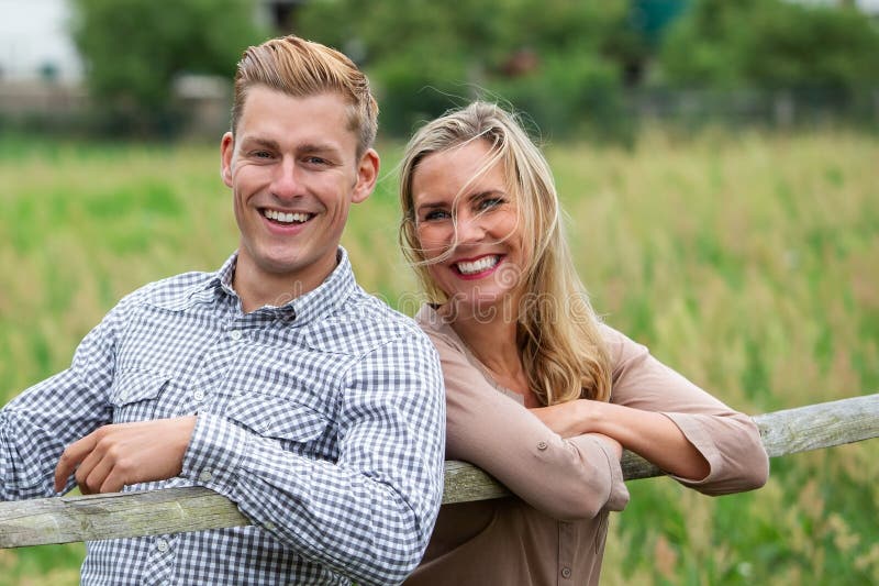 Portrait d'un jeune couple heureux riant dehors dans la nature