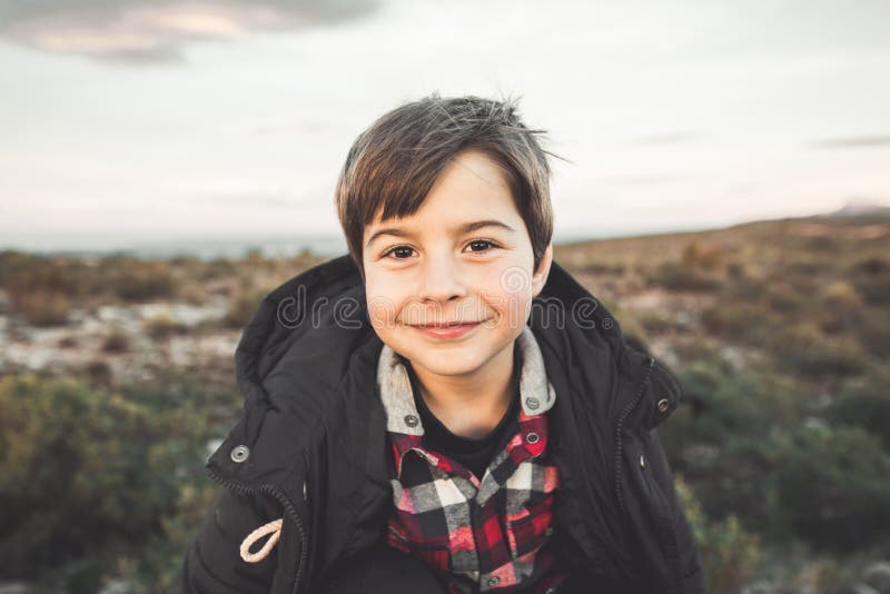 Portrait d'un petit garçon avec l'expression drôle et du sourire dans la campagne Enfant heureux photo stock Portrait d'un petit garçon avec l'expression drôle et du sourire dans la campagne Enfant heureux photo stock