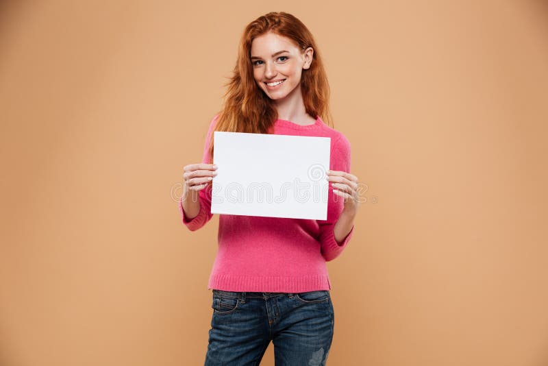 Portrait d'un sourire fille assez rousse tenant le conseil vide photo stock Portrait d'un sourire fille assez rousse tenant le conseil vide photo stock
