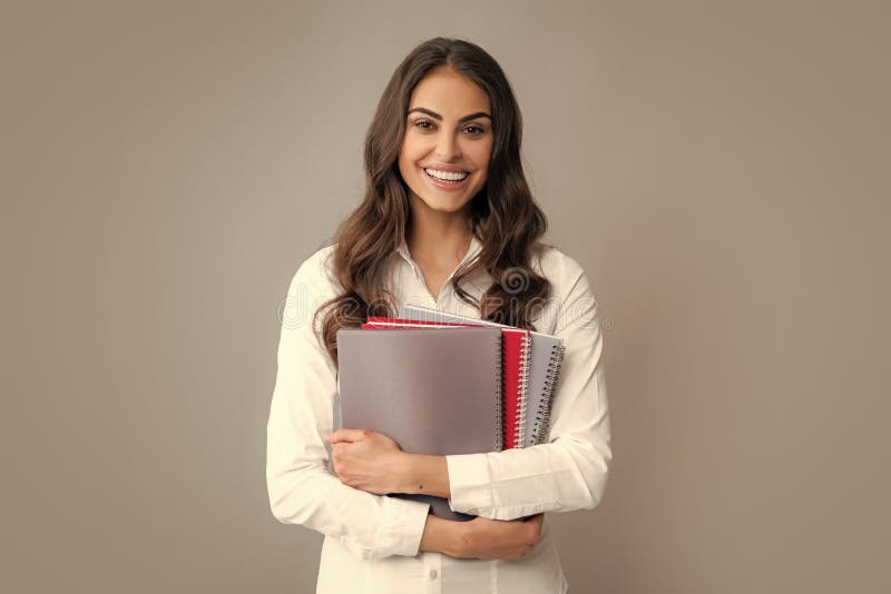 Portrait d'un étudiant souriant heureux ou d'un enseignant. enseignement collégial ou secondaire. jeune femme avec des cahiers sou