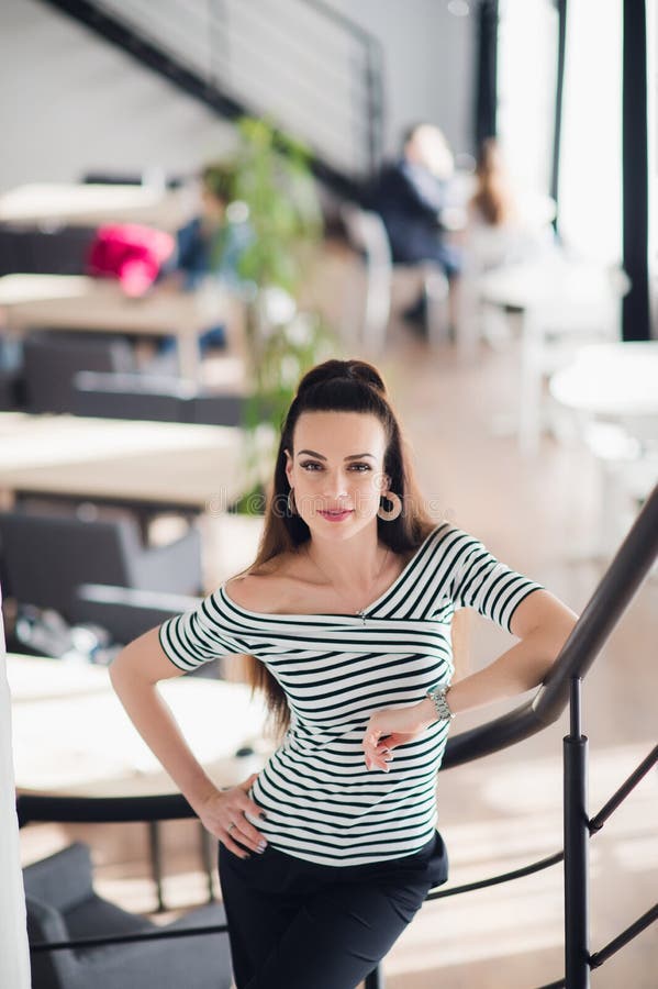 Portrait d'une belle femme regardant l'appareil-photo près de la grande fenêtre Propriétaire adulte de café avec un sourire de ac images stock Portrait d'une belle femme regardant l'appareil-photo près de la grande fenêtre Propriétaire adulte de café avec un sourire de ac images stock