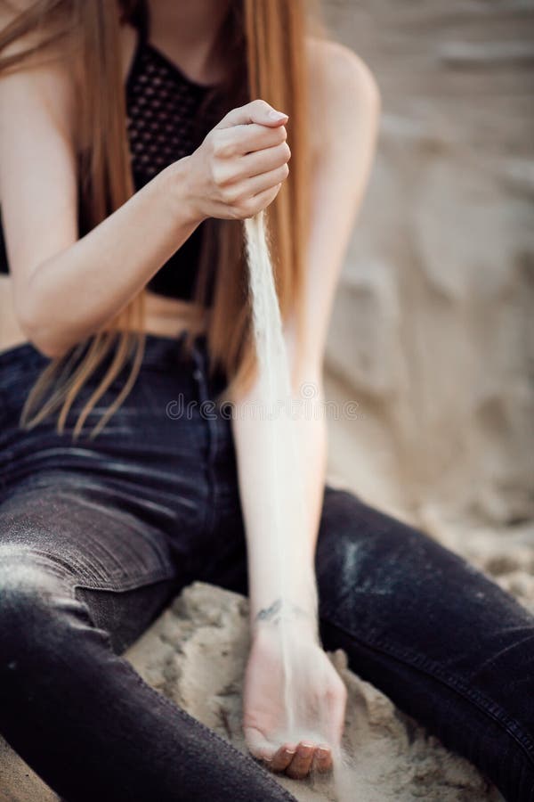 Portrait d'une belle fille avec de longs cheveux sur les sables dans la nature au coucher du soleil photographie stock Portrait d'une belle fille avec de longs cheveux sur les sables dans la nature au coucher du soleil photographie stock
