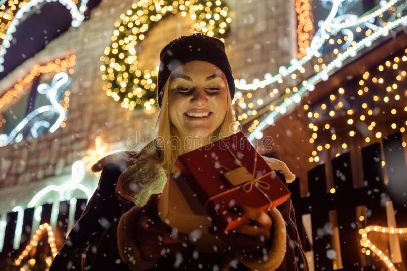 Portrait d'une belle fille qui ouvre un cadeau magique de Noël dedans photos libres de droits Portrait d'une belle fille qui ouvre un cadeau magique de Noël dedans photos libres de droits