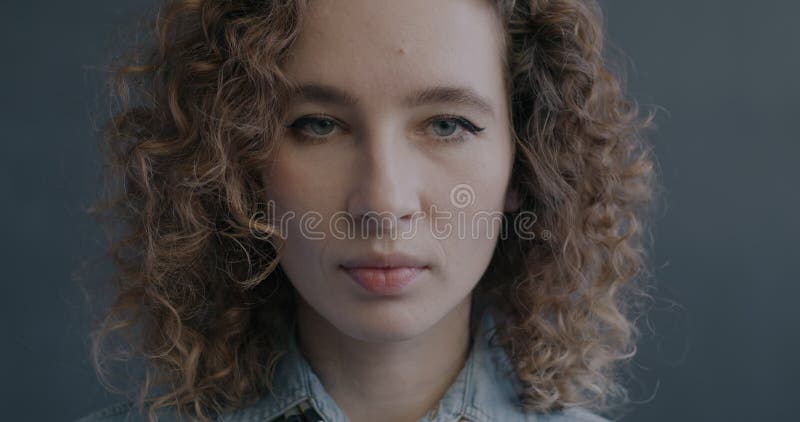 Portrait d'une belle jeune femme regardant la caméra avec une expression sérieuse du visage clips vidéos