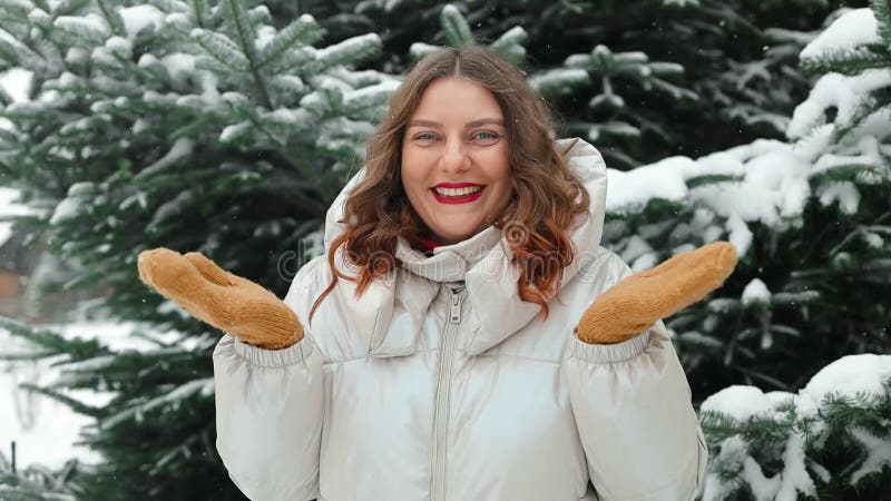Portrait d'une belle jeune fille joyeuse femme positive en train de jouer avec des flocons de neige en s'amusant dehors banque de vidéos