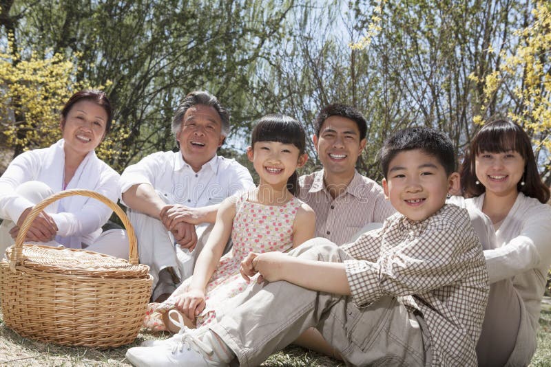 Portrait d'une famille multi-de generations ayant un pique-nique et appréciant le parc pendant le printemps photos stock Portrait d'une famille multi-de generations ayant un pique-nique et appréciant le parc pendant le printemps photos stock