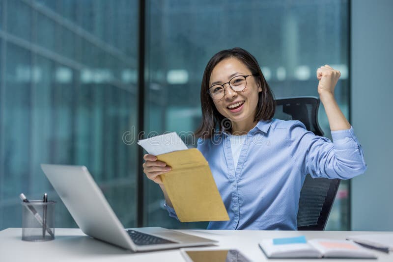 Portrait d'une femme d'affaires prospère au bureau au travail. Employé de bureau regardant la caméra tenant une enveloppe postale images stock