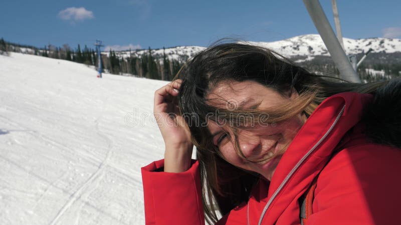 Portrait d'une femme caucasienne souriant devant la caméra pendant qu'elle est assise sur un téléski