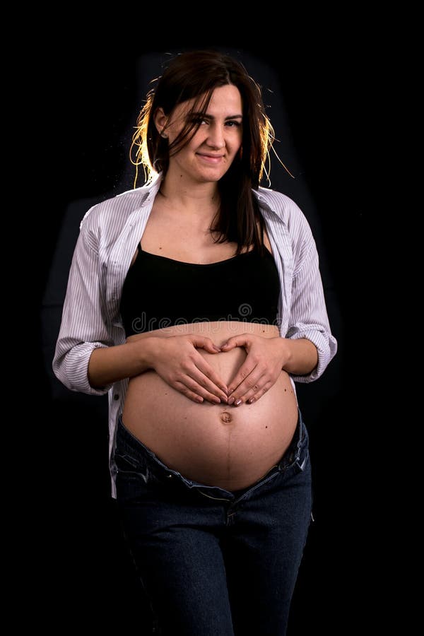 Portrait d'une femme enceinte sur un fond noir photos stock Portrait d'une femme enceinte sur un fond noir photos stock