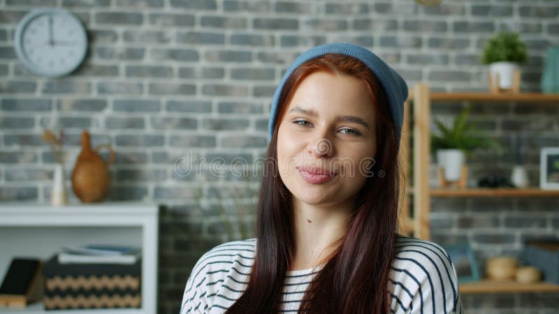 Portrait d'une femme sérieuse qui commence à sourire et à flirter en regardant la caméra à l'intérieur clips vidéos