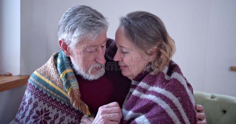 Portrait d'une femme âgée de couple héberge son mari avec un plaid chaud et se couvre. entre eux les armes clips vidéos