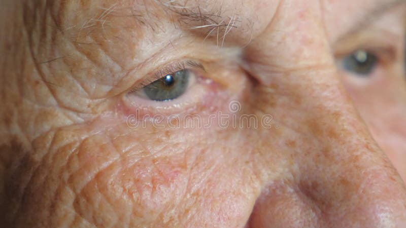 Portrait d'une femme âgée regardant pensive à quelque chose. Fermer les yeux des femmes avec des rides autour. Grand-mère clips vidéos