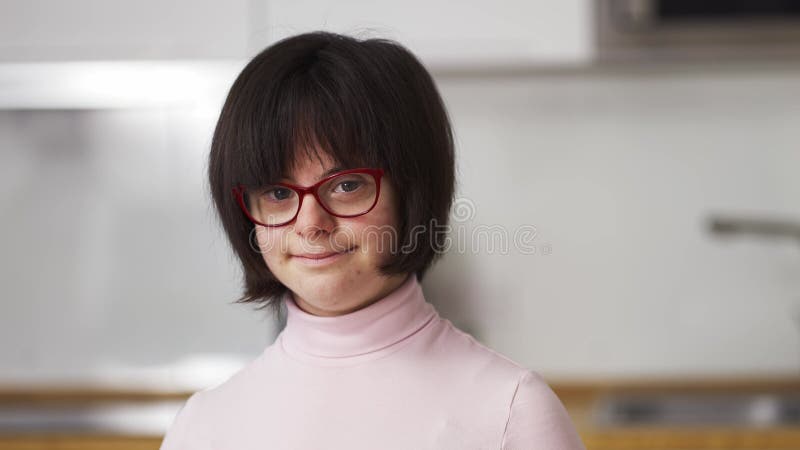 Portrait d'une fille heureuse avec le syndrome du bas dans les lunettes de vue banque de vidéos