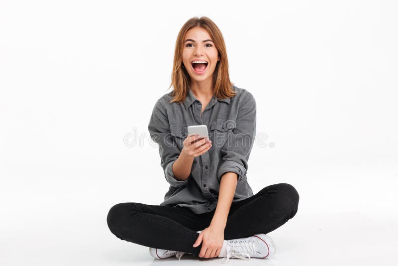 Portrait d'une fille heureuse gaie tenant le téléphone portable