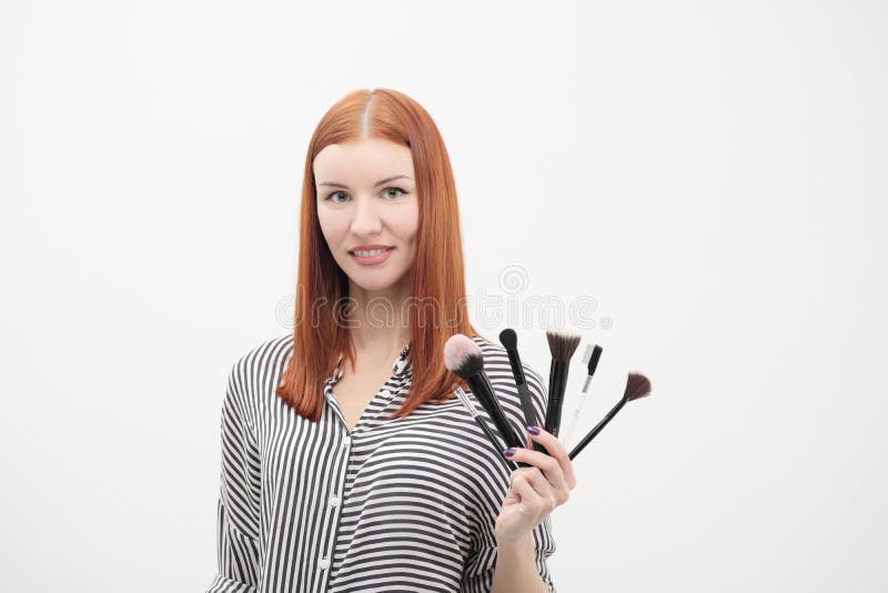 Portrait d'une fille rousse, maquillage d'acteur, professionnel sur le fond blanc Les pinceaux et la palette à disposition photos stock Portrait d'une fille rousse, maquillage d'acteur, professionnel sur le fond blanc Les pinceaux et la palette à disposition photos stock