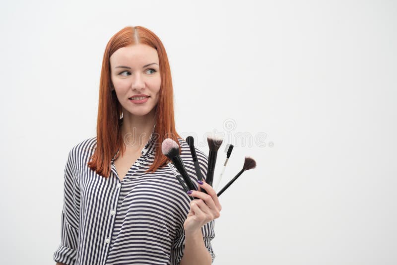 Portrait d'une fille rousse, maquillage d'acteur, professionnel sur le fond blanc Les pinceaux et la palette à disposition photo stock Portrait d'une fille rousse, maquillage d'acteur, professionnel sur le fond blanc Les pinceaux et la palette à disposition photo stock