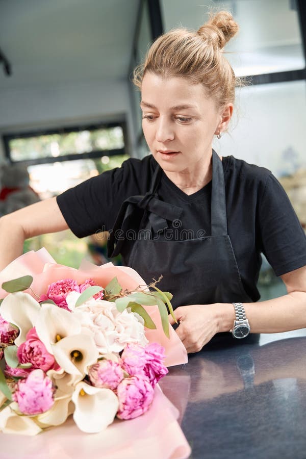 Portrait d'une fleuriste enthousiaste à l'oeuvre dans la boutique de fleurs image stock