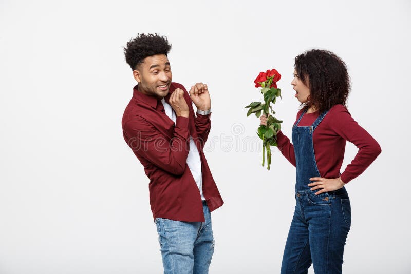 Portrait d'une jeune femme déçue tenant la rose de rouge avec tandis que debout et fâché sur son ami d'isolement plus de photo stock Portrait d'une jeune femme déçue tenant la rose de rouge avec tandis que debout et fâché sur son ami d'isolement plus de photo stock