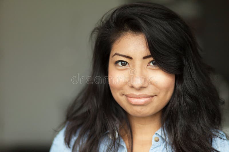 Portrait d'une jeune femme espagnole de sourire Elle est heureuse d'isolement sur le gris