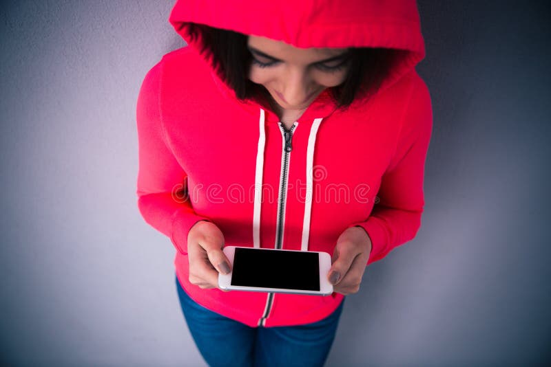 Portrait d'une jeune femme se tenant avec le smartphone photos stock Portrait d'une jeune femme se tenant avec le smartphone photos stock