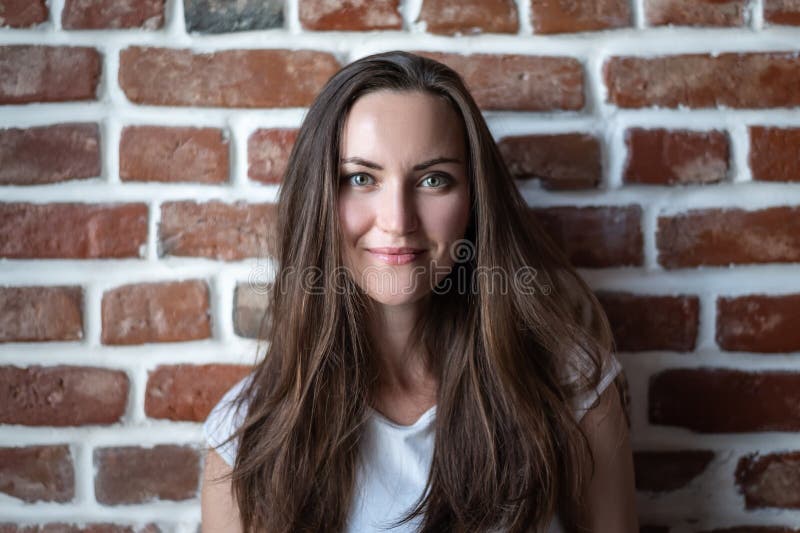 Portrait d'une jeune femme sur un fond rouge de mur de briques photos stock Portrait d'une jeune femme sur un fond rouge de mur de briques photos stock