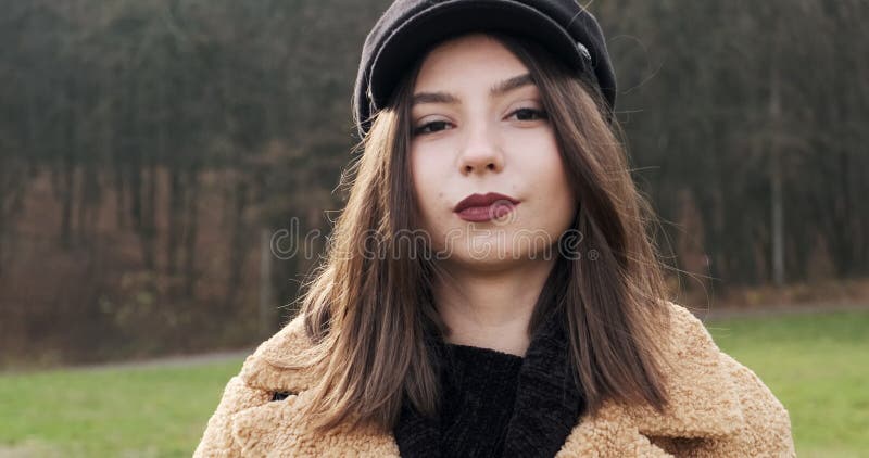 Portrait d'une jeune femme séduisante qui sourit et regarde la caméra sur la pelouse verte Jolie femme avec clips vidéos