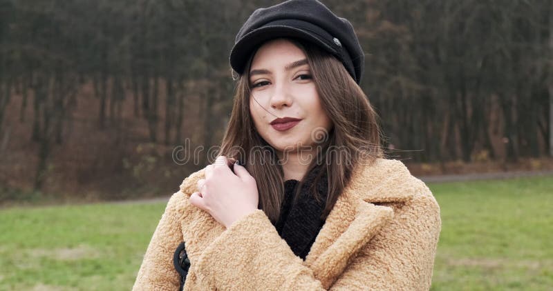Portrait d'une jeune femme séduisante qui sourit et regarde la caméra sur la pelouse verte Jolie femme avec banque de vidéos