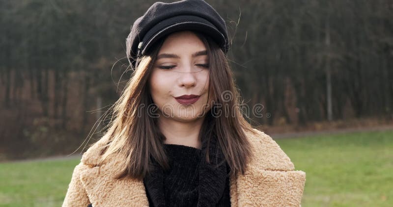 Portrait d'une jeune femme séduisante qui sourit et regarde la caméra sur la pelouse verte Jolie femme avec banque de vidéos