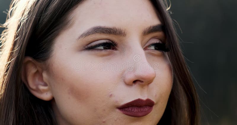 Portrait d'une jeune femme séduisante qui sourit et regarde la caméra sur la pelouse verte Jolie femme Fermer banque de vidéos