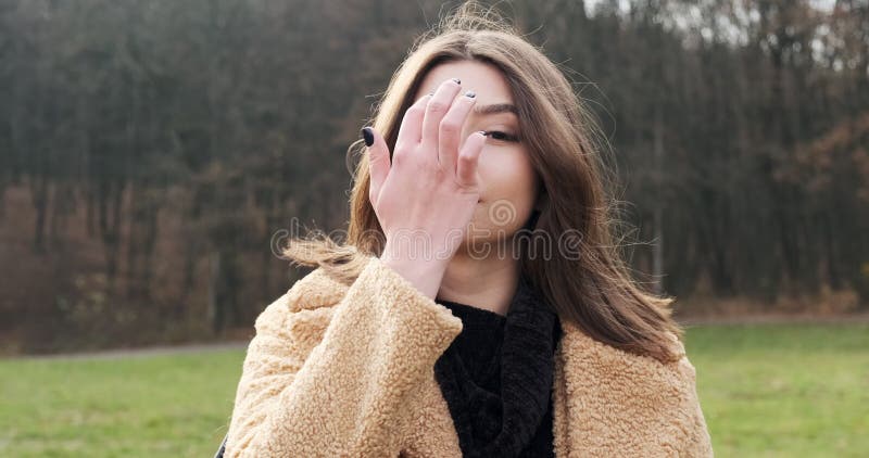 Portrait d'une jeune femme séduisante qui sourit et regarde la caméra sur la pelouse verte Jolie femme Fermer banque de vidéos