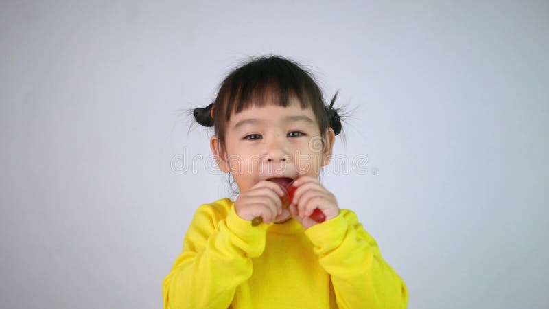 Portrait d'une jeune fille asiatique souriante et heureuse de manger de la gélatine dessert isolé sur fond blanc banque de vidéos
