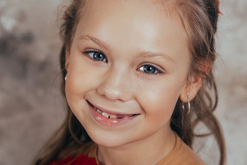 Portrait d'une jeune fille de sourire dans une robe rouge et avec une belle coiffure Projectile de studio photographie stock Portrait d'une jeune fille de sourire dans une robe rouge et avec une belle coiffure Projectile de studio photographie stock