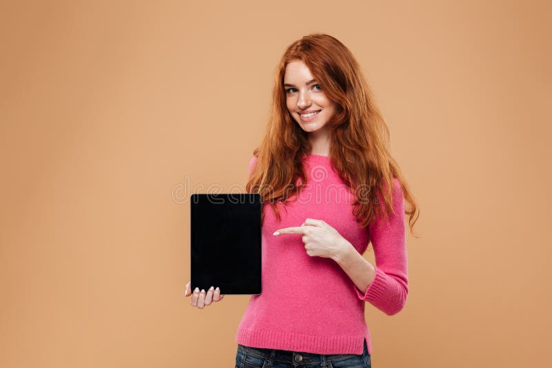 Portrait d'une jeune fille rousse de sourire dirigeant le doigt images stock Portrait d'une jeune fille rousse de sourire dirigeant le doigt images stock